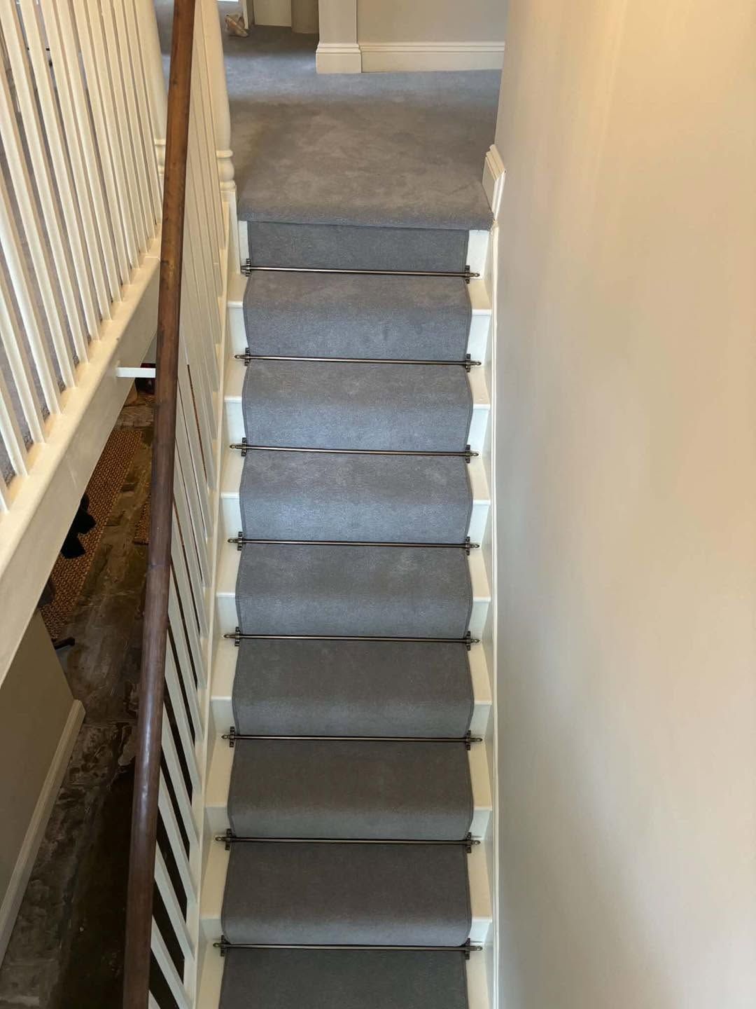 Grey stair runner held with dark stair rods