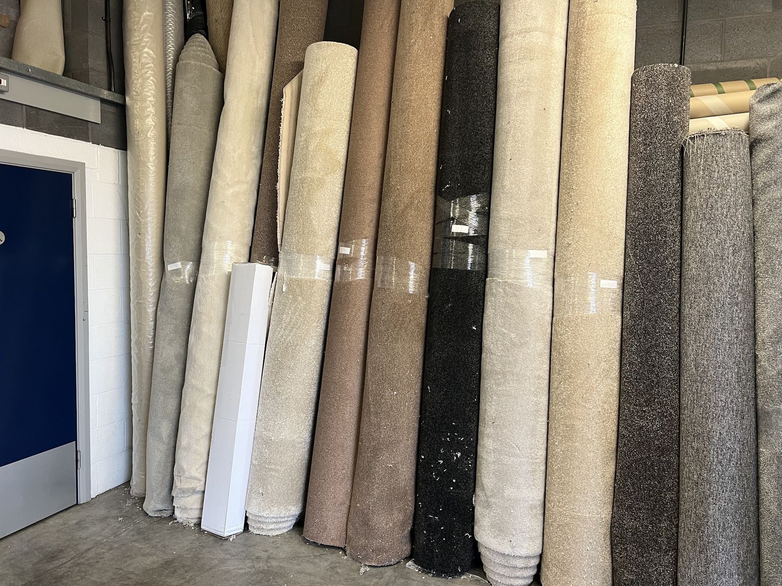 A row of carpet rolls stood upright in the unit